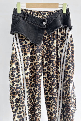 Leopard print pants with black denim waistband on a white background