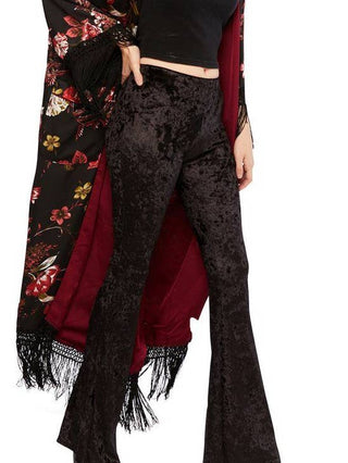 Black crushed velvet bell bottom pants with a dramatic flared leg and light-catching velvet texture.