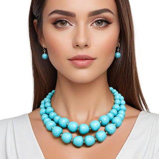 Woman wearing a turquoise necklace and earrings on a white background