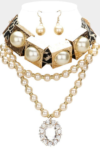 Pearl necklace and earrings set on a mannequin bust with a white background