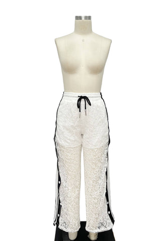 White lace pants with black accents on a mannequin against a white background