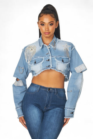 Front view of the Medley cropped denim jacket featuring rhinestone fringe, star trim, button front and chest pockets.