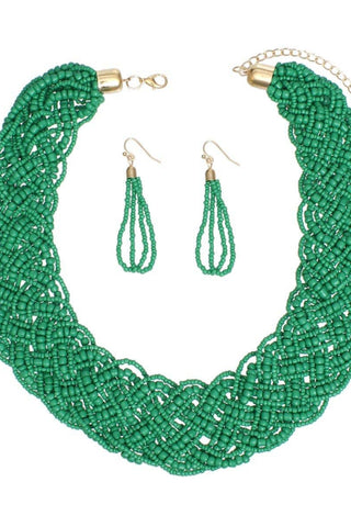 Green beaded necklace and earrings set on a white background