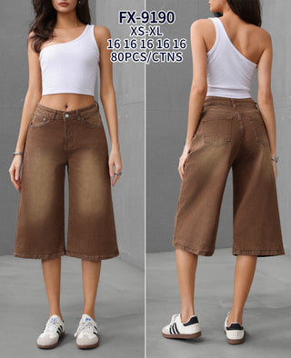 Brown stretch denim jorts with a mid-length wide-leg silhouette, classic five-pocket styling, and button-zip front.