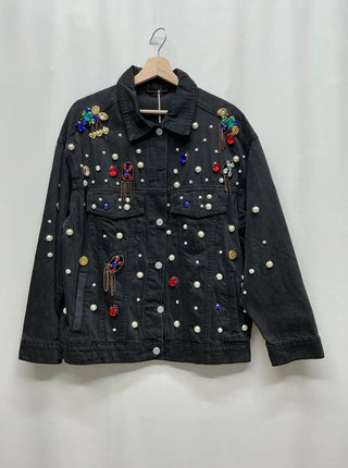 Black washed denim jacket with scattered faux pearls, multicolored faceted gems, gold-tone accents, button front, and flap pockets.