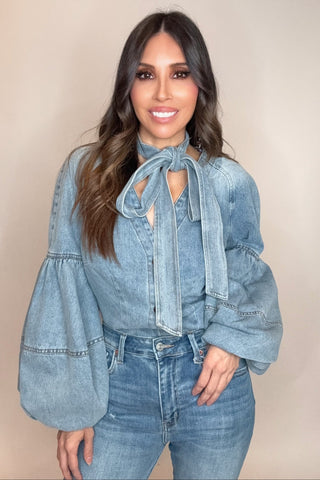 Woman wearing a denim outfit with a beige background