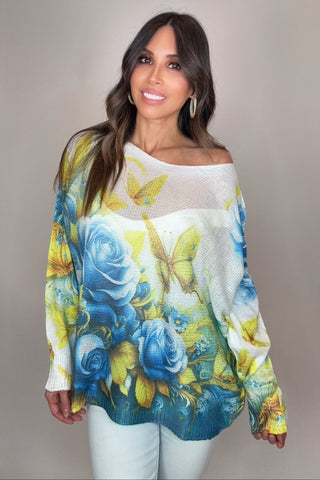 Woman wearing a colorful floral sweater against a plain background
