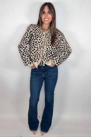 Woman wearing a leopard print jacket and blue jeans on a white background