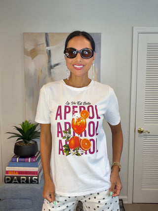 White short sleeve graphic tee with bold pink Summer Aperol lettering and colorful cocktail artwork on the front.