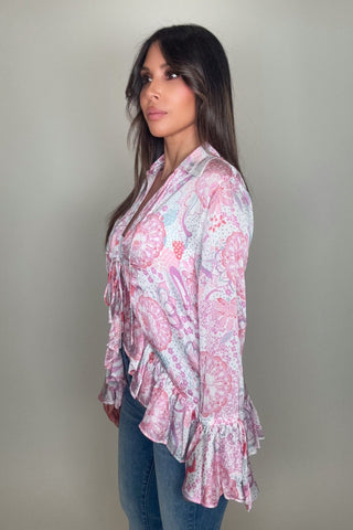 Woman wearing a pink floral blouse against a plain background