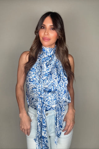 Woman wearing a blue patterned top against a plain background