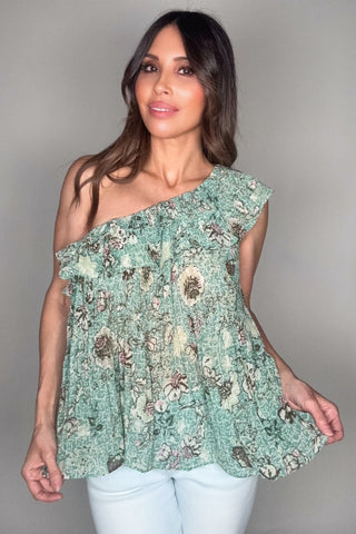 Woman wearing a floral one-shoulder top against a plain background