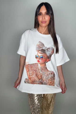Woman wearing a white t-shirt with a graphic design of a woman holding a clutch.