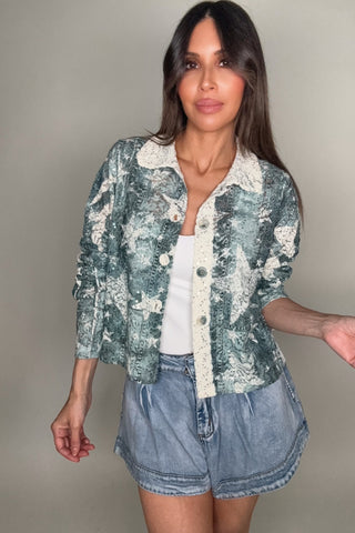 Woman wearing a star jacket and denim shorts against a plain background