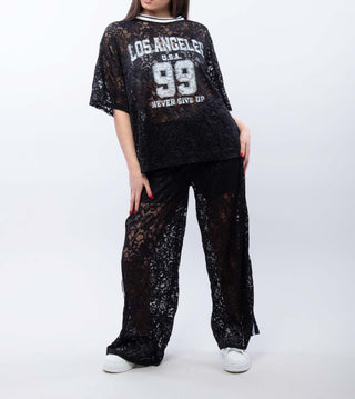 Black lace lounge set with a short sleeve Los Angeles graphic top and relaxed wide-leg pants styled as a sporty feminine co-ord.