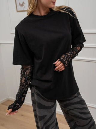 Black lace sleeve thumbhole tee with a scoop neckline and sheer lace long sleeves for a feminine boutique look.