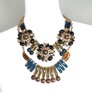 Blue and brown floral layered necklace with a gold chain, floral pendant, and gemstone accents.