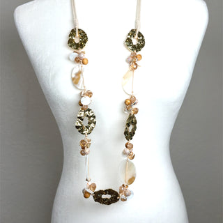 Long champagne and white shell necklace with gold-tone textured statement disks and natural shell bead accents.