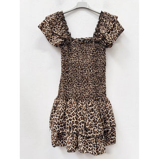 Leopard print mini dress on a hanger featuring a smocked bodice, square neckline, puff sleeves, and tiered ruffle skirt.