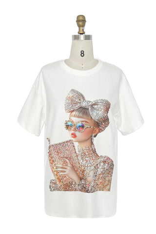 White t-shirt with a graphic of a person wearing sunglasses and a large bow on a mannequin against a white background.