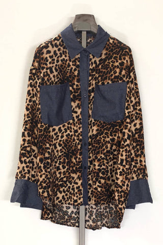 Leopard print shirt with blue accents on a hanger against a white background