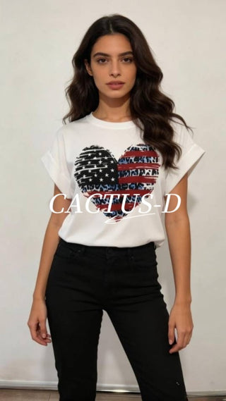 Woman wearing a white t-shirt with a heart-shaped American flag graphic and black jeans, styled in a boutique casual look.