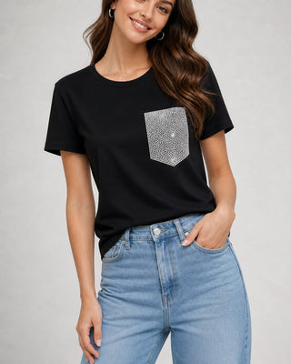 Woman wearing a black short sleeve crewneck top with a sparkling crystal-embellished pocket styled with light blue jeans.