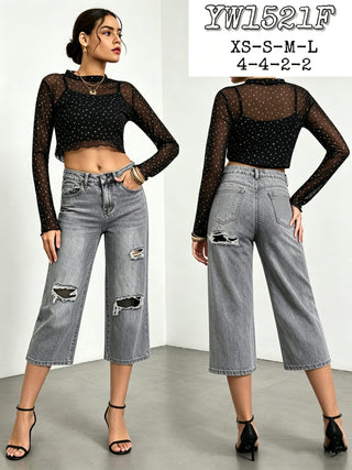 Front and back view of grey distressed crop wide leg jeans with ripped details, styled with a black mesh top and black heels