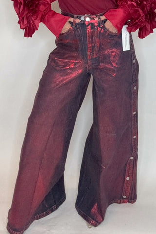 Person wearing a burgundy outfit with ruffled sleeves against a white background