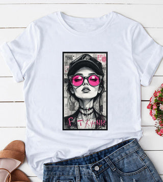 White t-shirt with bold graphic of woman in pink sunglasses and cap, styled with denim shorts