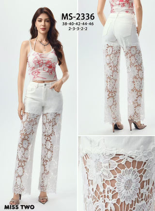 White high-rise straight leg jeans modeled with heels, featuring sheer floral lace panels from thigh to hem.